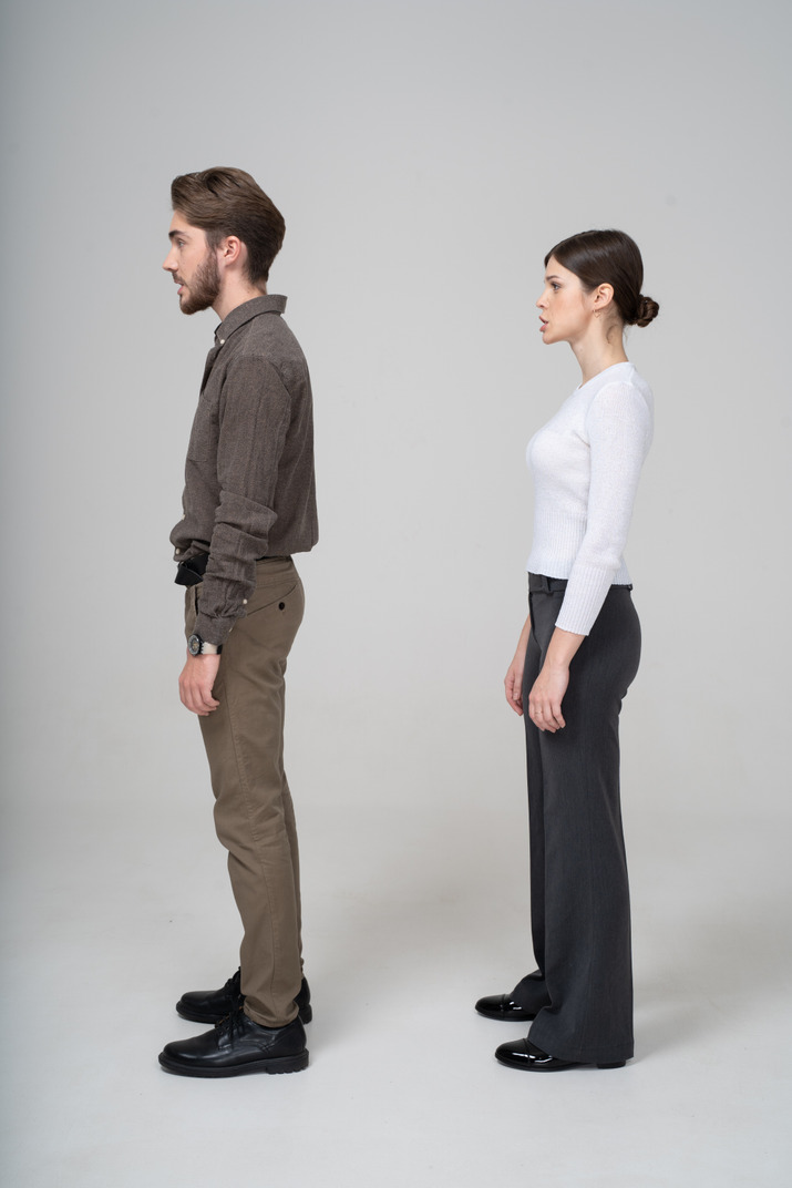 Side view of a grimacing young couple in office clothing