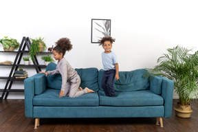 Good looking boy and girl play on the sofa