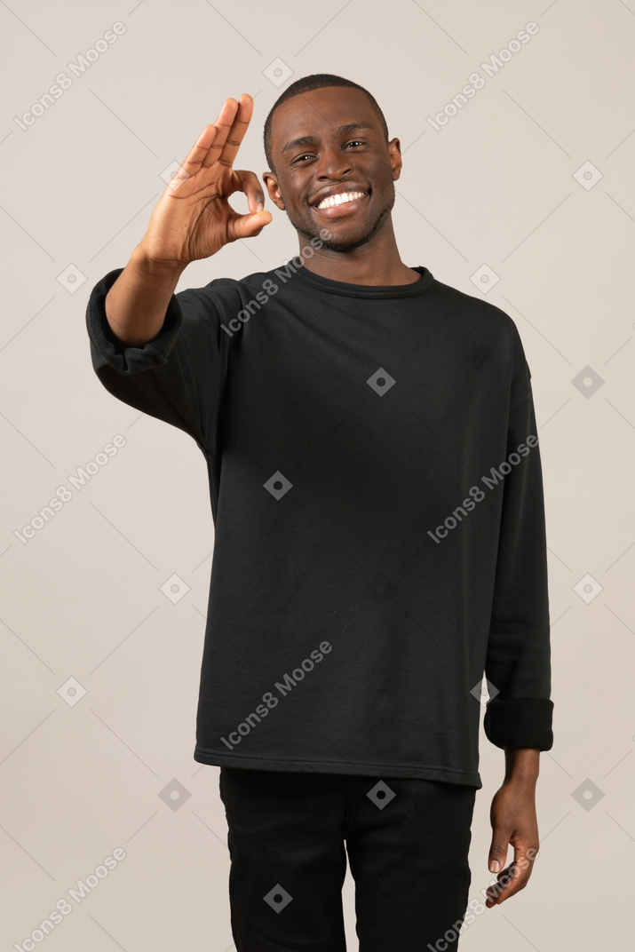 Smiling young man showing ok sign