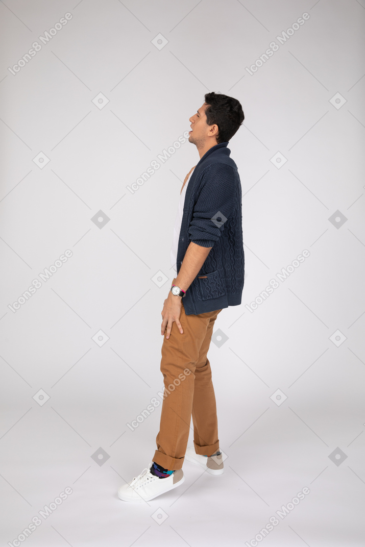 Side view of man in blue cardigan and brown pants