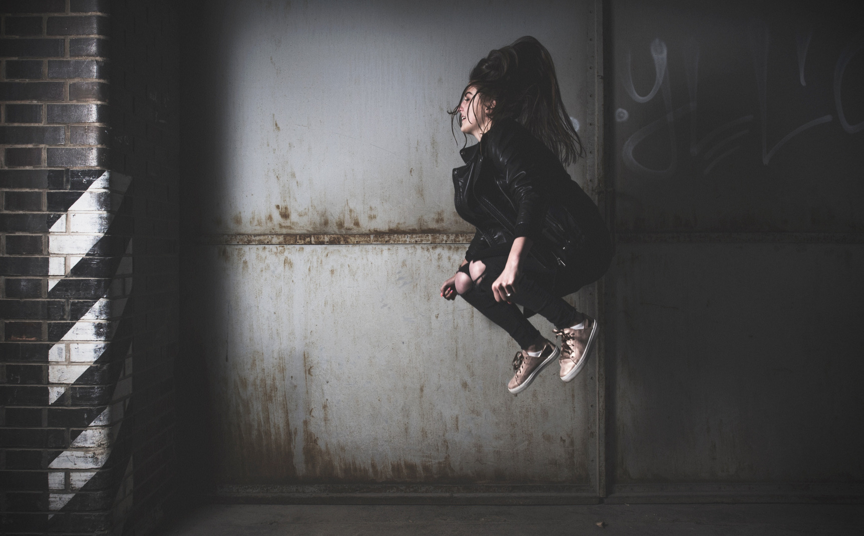 Vista lateral de uma jovem pulando alto