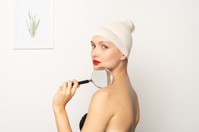 Side view of a young woman holding magnifying glass