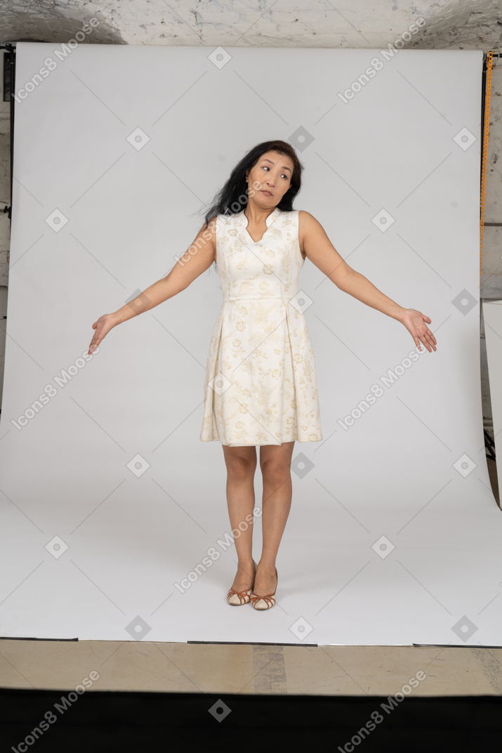 Женщина в белом платье стоит