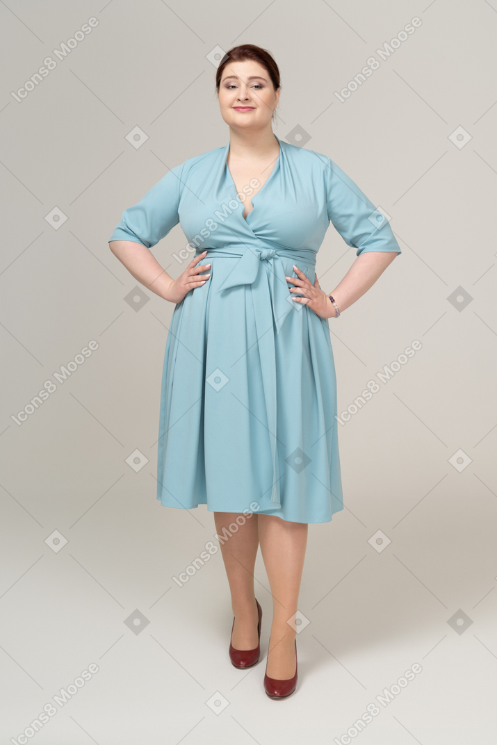 一个身着蓝色裙子、双手叉腰的女人的前视图