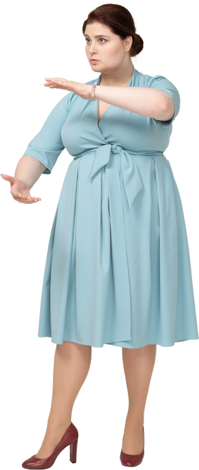 一个穿着蓝色连衣裙的女人的前视图，显示某物的大小