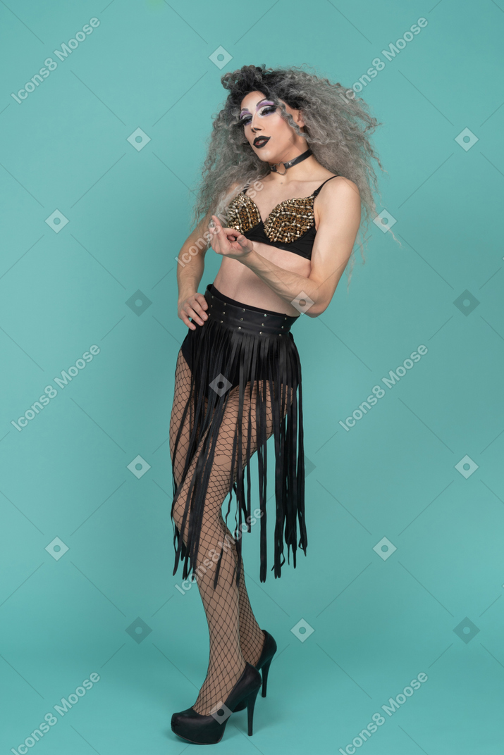 Drag queen in all black outfit beckoning with finger