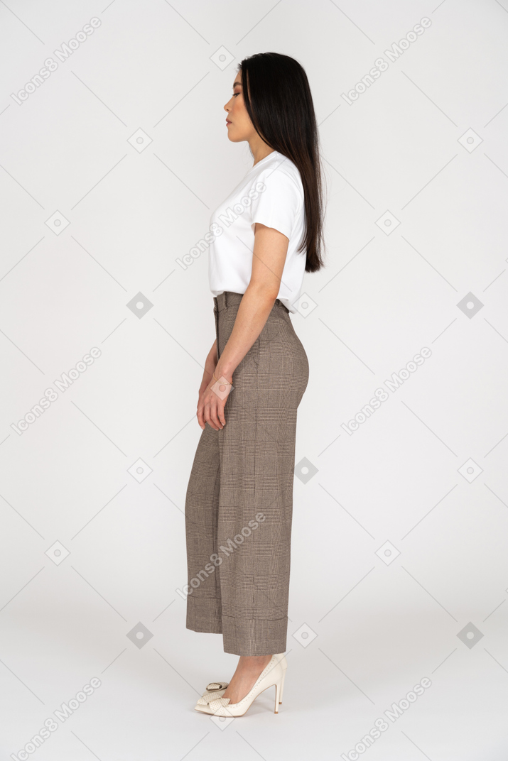 Vista lateral de una mujer joven en calzones de pie quieto mientras mira hacia abajo