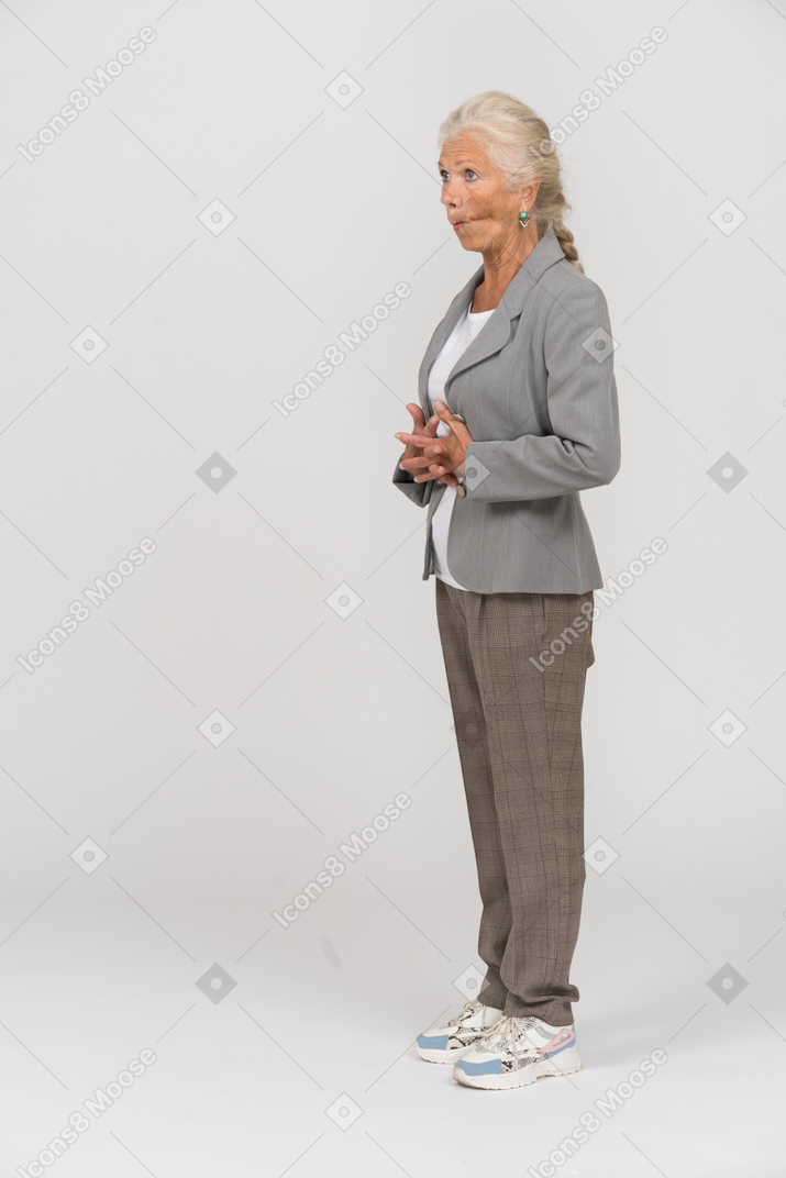 Anciana en traje posando de perfil y haciendo muecas