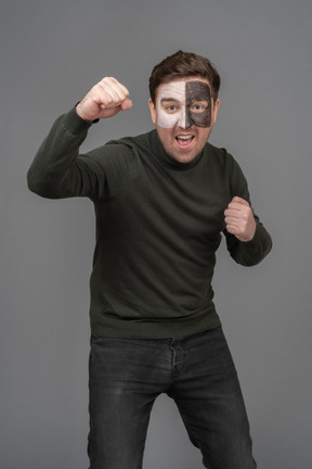 Front view of a cheerful male football fan raising hand & clenching fists