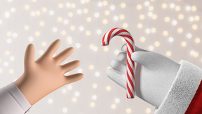 Santa's hand passing a candy cane to another hand