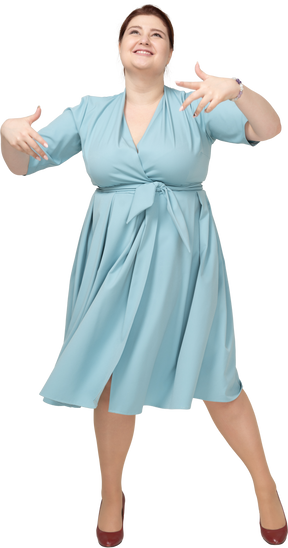 Vista frontale di una donna in abito blu che balla