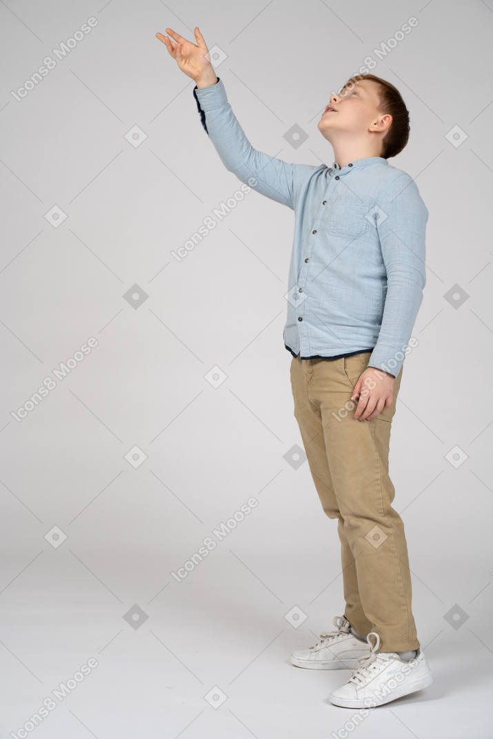 一个男孩用手向上的侧视图