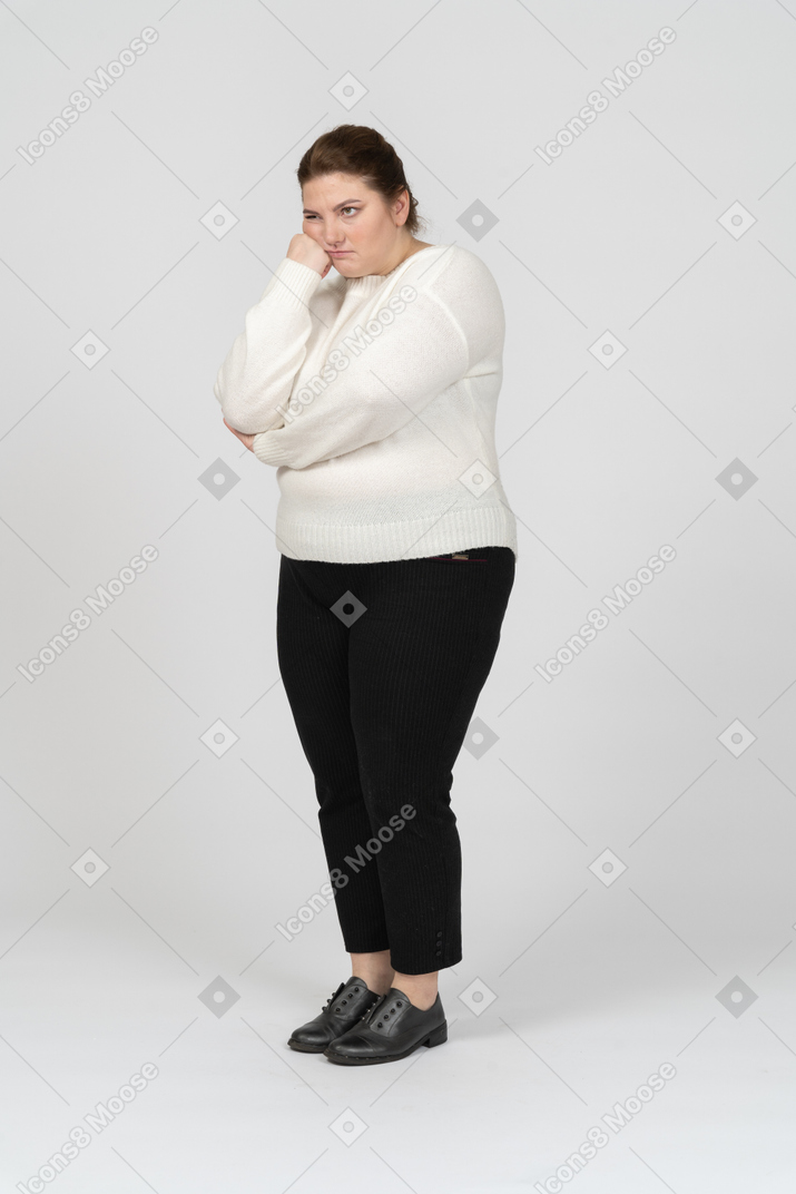 Vista frontal de uma mulher gordinha e cansada com roupas casuais, olhando para a câmera