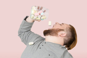 Man eating candy from jar