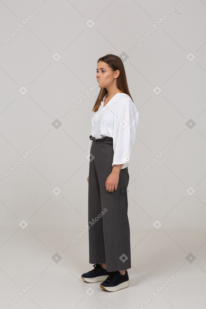 Three-quarter view of a smirking young lady in office clothing