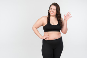 Smiling young plus-size model waving