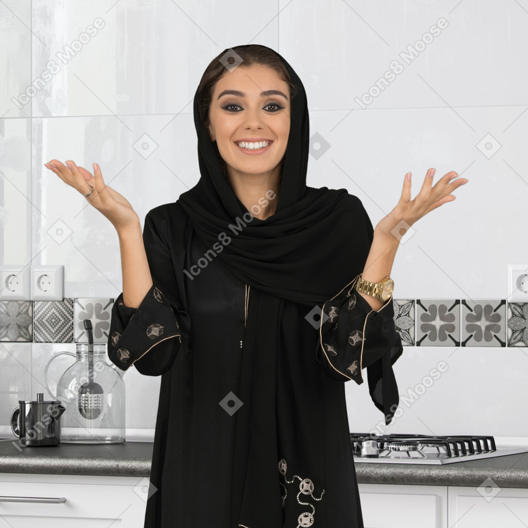 A woman in a black hijab standing in a kitchen