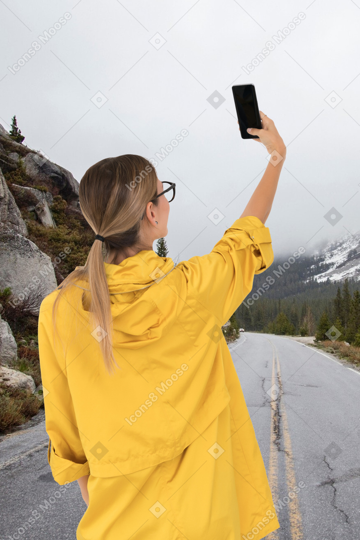 Une femme prenant une photo avec son téléphone portable