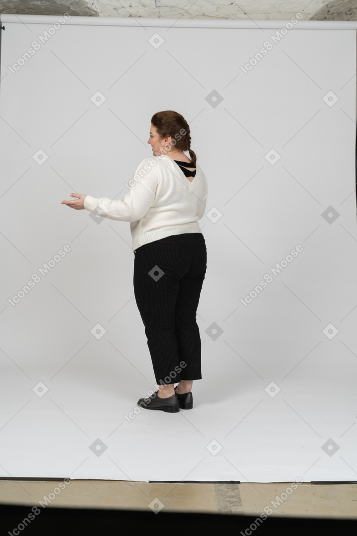 Side view of a plump woman in white sweater gesturing