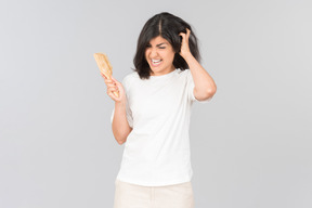 Irritée jeune femme indienne tenant la brosse à cheveux