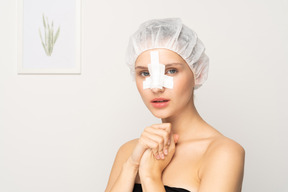 Portrait of a young woman with her nose bandaged