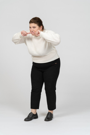 Mulher rechonchuda em suéter branco fazendo caretas