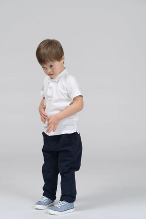 Little boy standing with his hands on his stomach