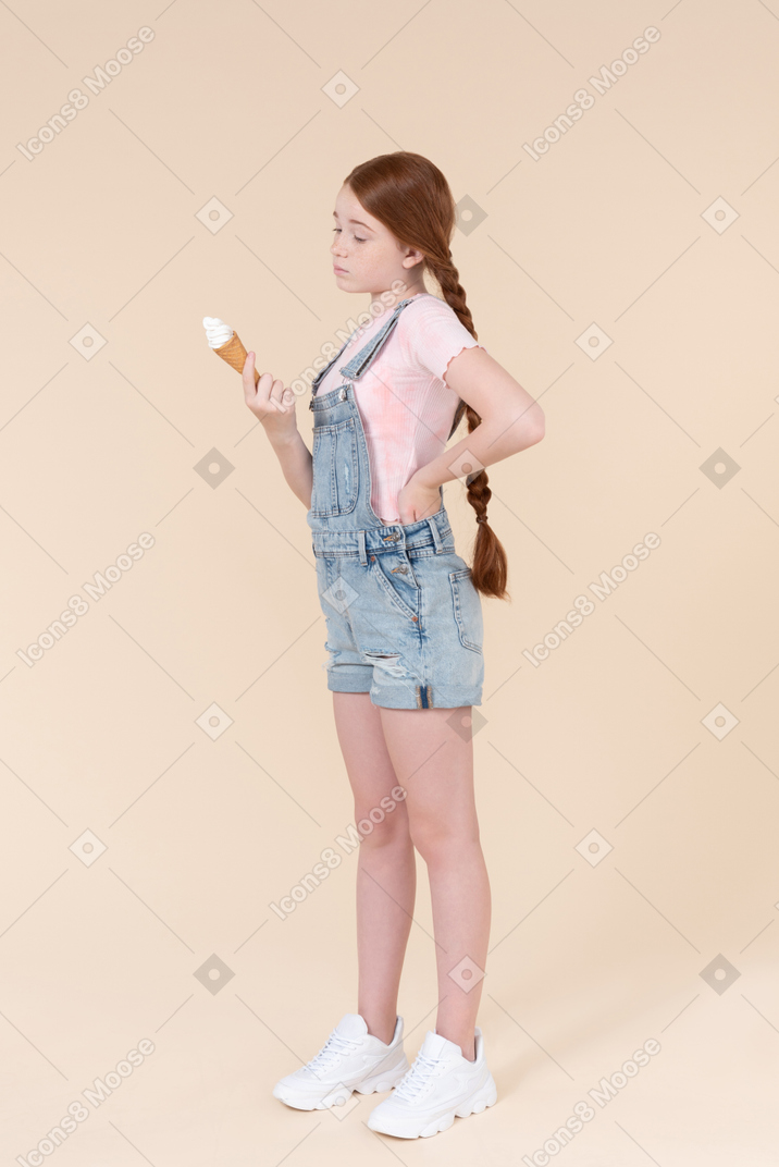Teenager girl looking at ice cream she's holding