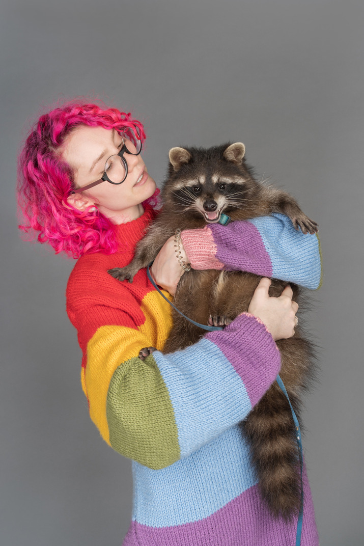 Young woman holding a racoon