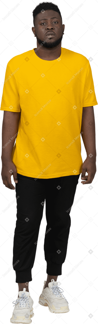 Вид спереди на стоящего на месте молодого темнокожего мужчины в желтой футболке