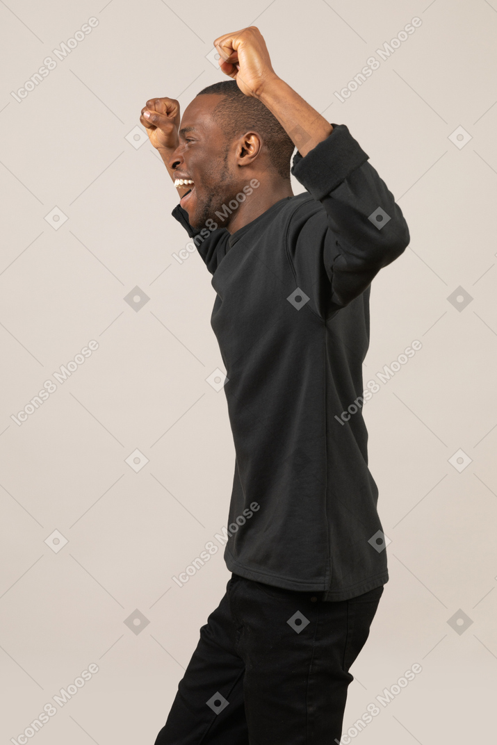 Side view of happy young man celebrating success