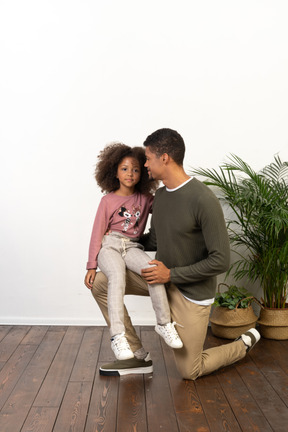 Young man on a knee with his daughter