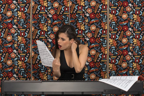 Shocked female pianist looking at musical notation