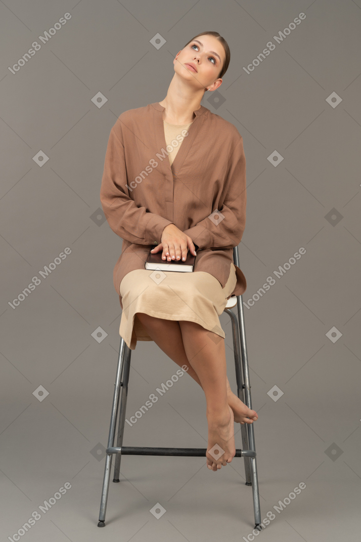 Giovane donna seduta e pensando a qualcosa