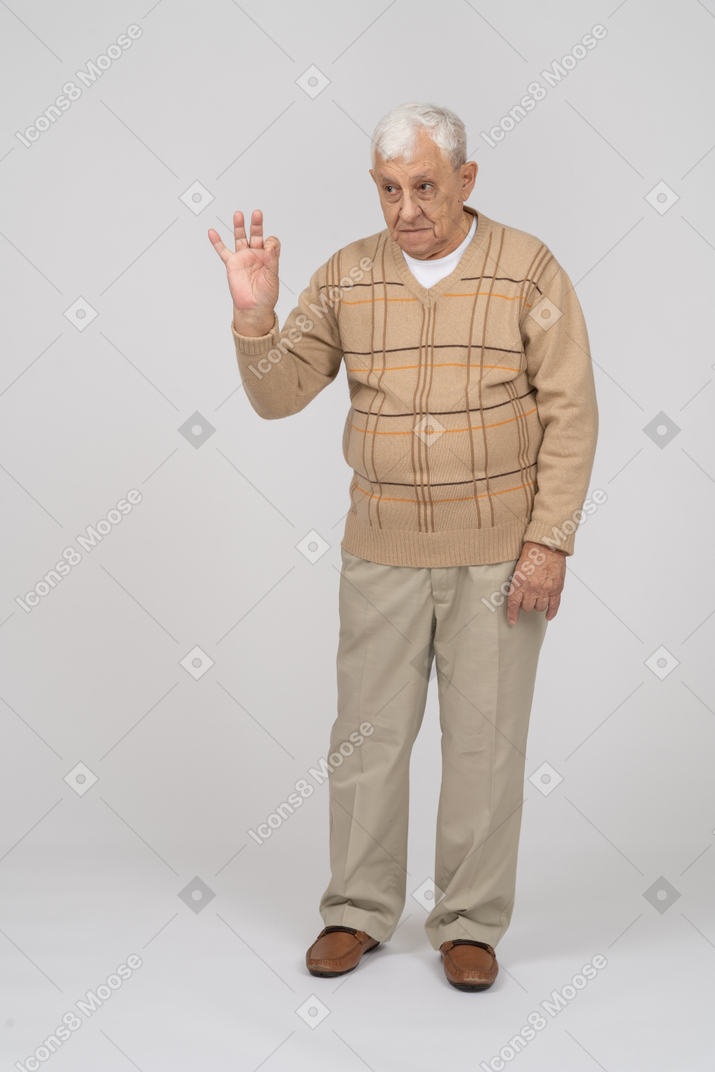 Vista frontale di un uomo anziano in abiti casual che mostra segno giusto
