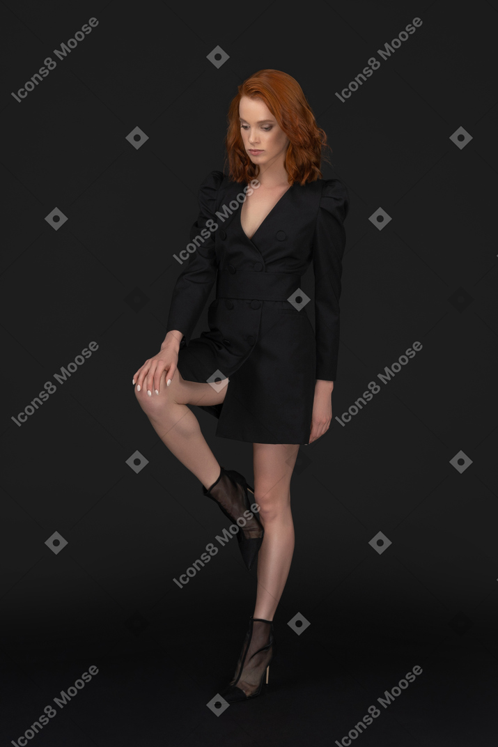 A frontal view of the cute young woman standing on one leg