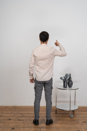 Vista traseira de um homem de terno mostrando o polegar para cima