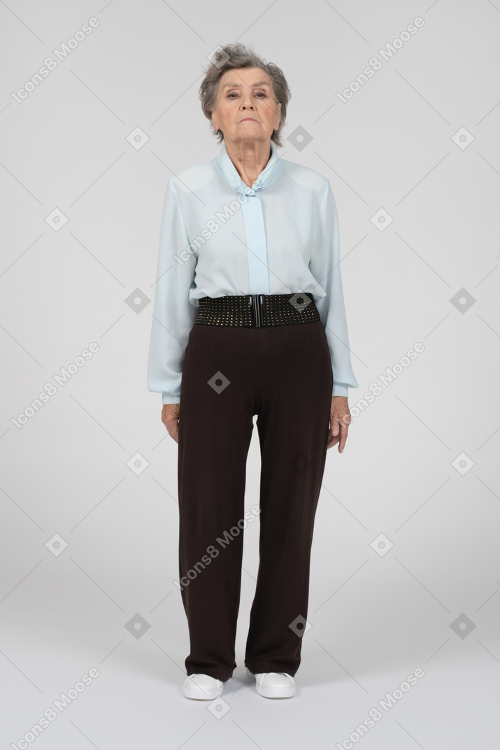 Old woman standing and looking at camera