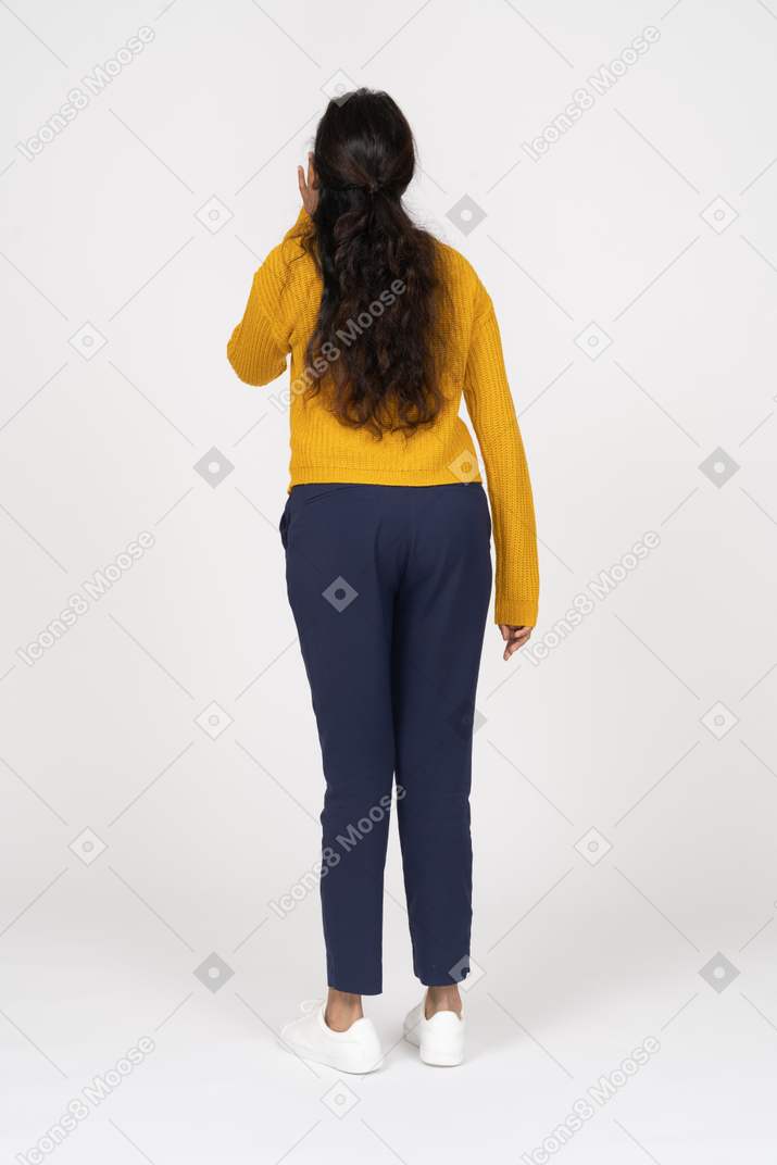 Rear view of a girl in casual clothes calling someone