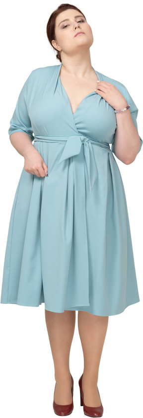 一个穿着蓝色连衣裙的女人抚摸脖子的前视图