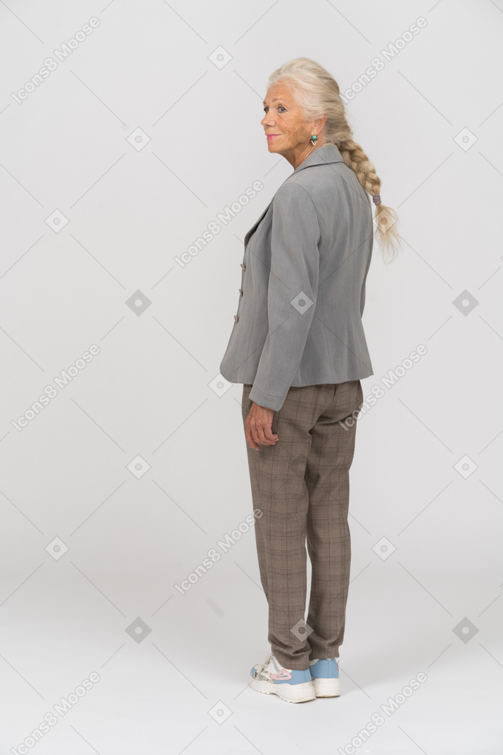 Vista posteriore di una vecchia signora in giacca e cravatta