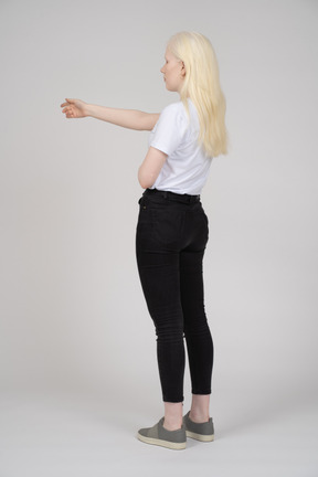 Vista posteriore di una donna dai capelli lunghi con il braccio proteso