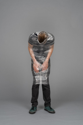 Front view of a young man wrapped in plastic