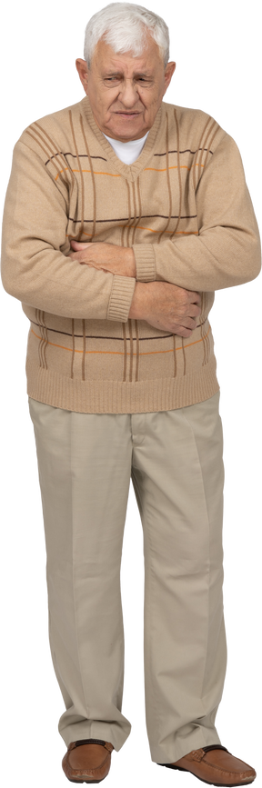 Front view of an old man in casual clothes suffering from stomachache
