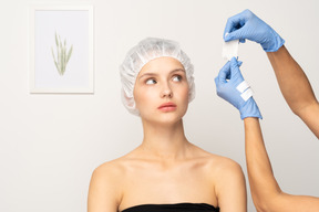 Doctor putting gauze on young woman's face