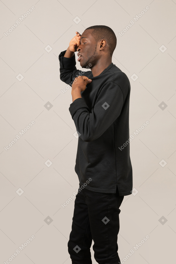 Side view of a man touching forehead