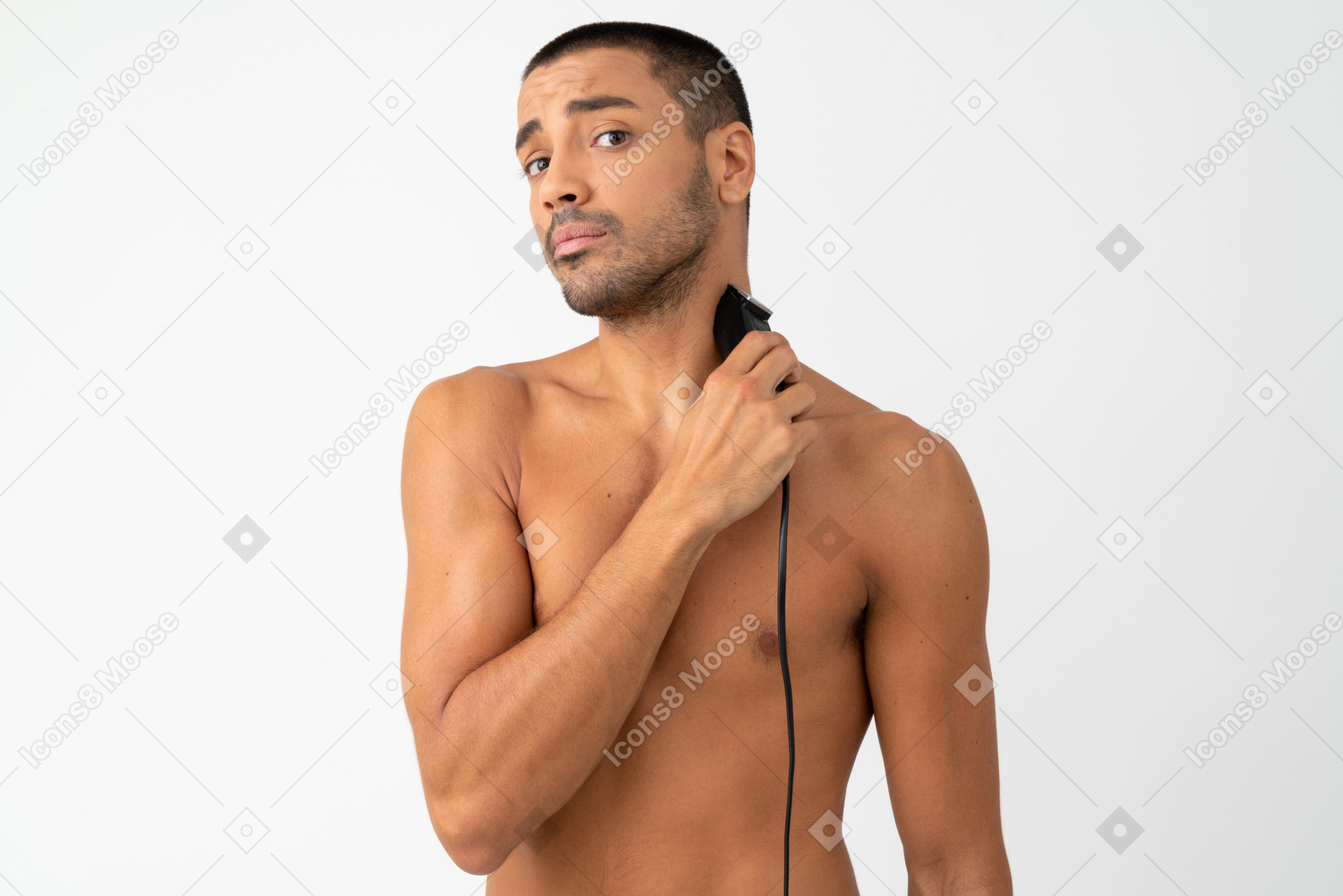 Barechested young man shaving with al electric razor