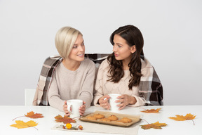 Giovani donne che bevono caffè e si guardano