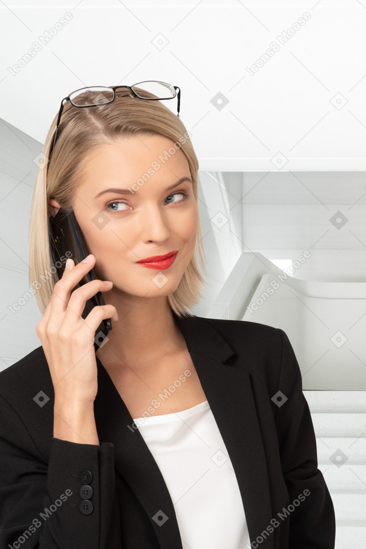 A woman in a business suit talking on a cell phone