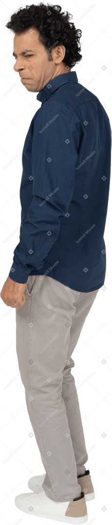 Side view of a man in casual clothes making faces